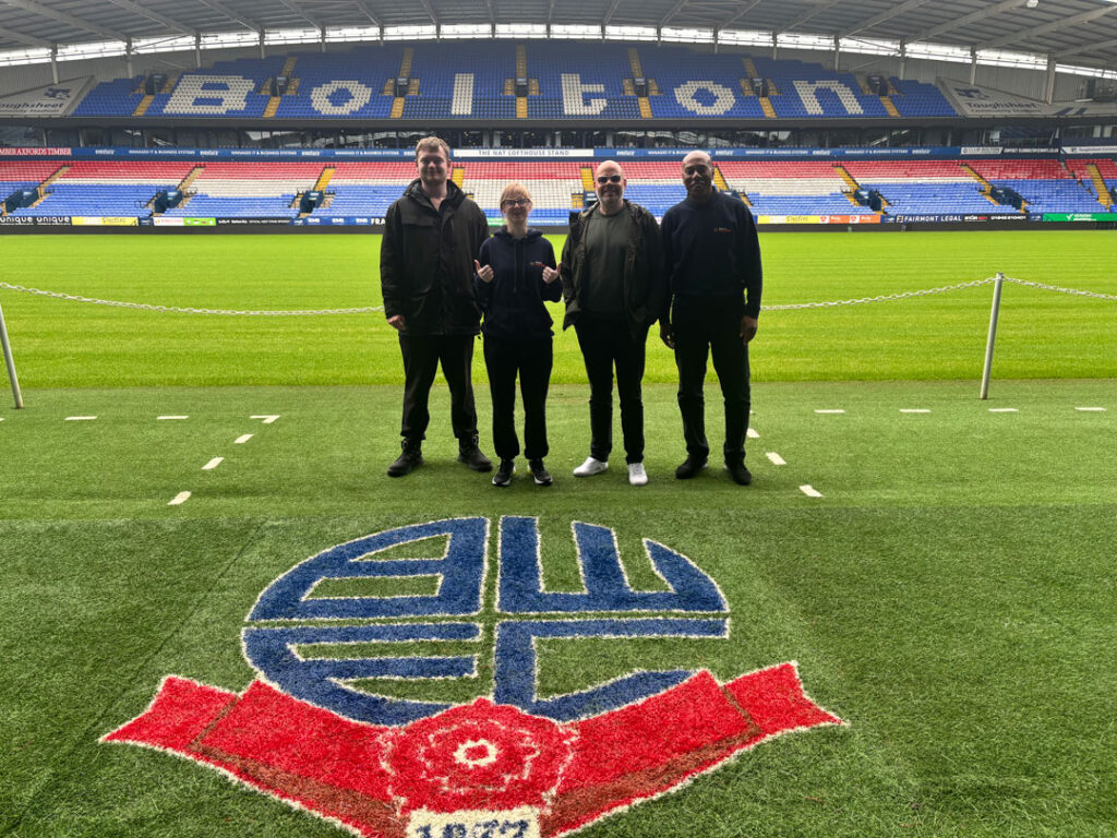 Genuine Futures Youth Ambassador Luis Green leads discussions with Bolton Wanderers in the Community CEO Ben Lawton about creating opportunities for young people in Bolton through employability, enterprise, youth leadership, and community engagement initiatives.